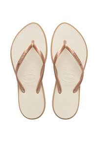 Brown rubber flip-flops with textured white soles. Features Havaianas branding and thin brown straps, shaped for comfort and ease of wear.