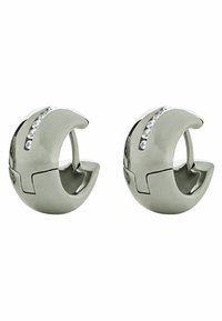 Orecchini a cerchio in argento con un design morbido e arrotondato, caratterizzati da una fila di cristalli trasparenti su un lato. Superficie riflettente e finitura lucida.