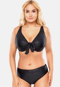 Conjunto de bikini negro que presenta un top con escote en V y un lazo central, con tirantes anchos, combinado con una parte inferior de talle alto a juego, ambos en tejido texturizado.