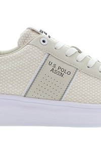 Sneaker bianco con tomaia in rete testurizzata, dettagli in pelle liscia, rifiniture perforate, marchio laterale e suola in gomma bianca.