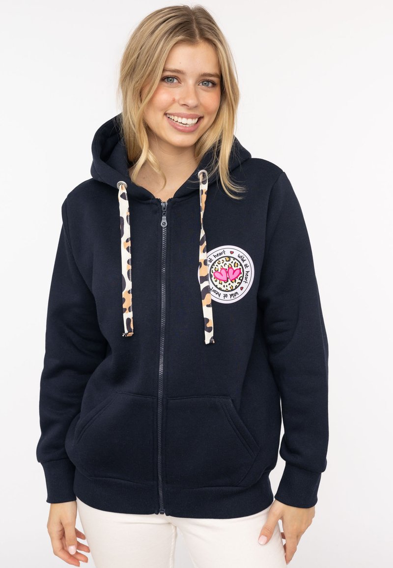 Marineblaue Zip-Hoodie aus Baumwolle mit einer Zugkordel im Leopardenmuster, ausgestattet mit einem runden Aufnäher mit bunten Herzen auf der linken Brust.