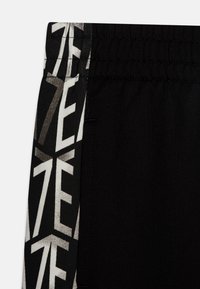 Zwarte sportshorts met een gestructureerde tailleband, zijaccenten met een gedurfde witte grafische print en een duurzame stofconstructie.