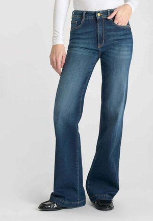 Jeans a vita alta a palazzo realizzati in denim blu scuro, con chiusura frontale con bottone, cinque tasche e cuciture a contrasto.