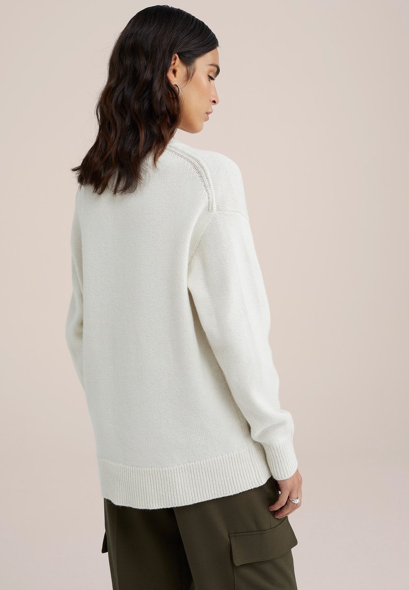 Beigefarbener Pullover mit lockerem Schnitt, gerippten Bündchen und Saum. Die Strickstruktur und die überschnittenen Schultern verleihen einen lässigen Look.