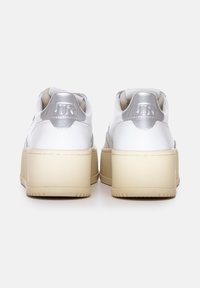Witte platform sneakers met zilveren accenten, bovenwerk van textured leer, gevoerde kraag en rubberen loopzool. Voorzien van een gegraveerd logo op de hak.