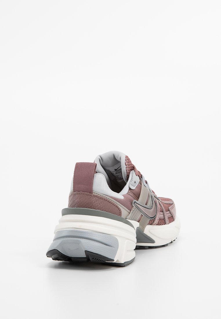 Zapatilla deportiva con parte superior de malla en color burdeos y gris, suela de goma, collar acolchado en el tobillo y un branding destacado en el lateral.