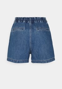 Farkkushyvät, joissa on vaaleansininen pesu, elastinen vyötärö ja kaksi takataskua. Shortseissa on yksinkertainen, rento leikkaus ja näkyvät saumat.