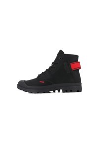 Sneaker nera a metà altezza in materiale scamosciato, suola in gomma, cinturino rosso attorno alla caviglia e lacci neri. Dettagli in superficie testurizzati sui lati.