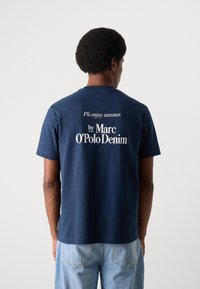Camiseta de algodón azul marino con cuello redondo y mangas cortas, con texto blanco en la parte posterior que dice "Por favor, disfruta del verano. por Marc O'Polo Denim."
