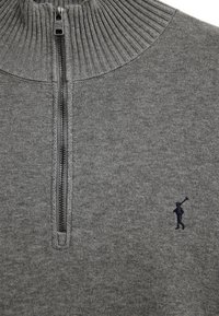 Grauer Strickpullover mit geripptem Stehkragen, halbem Reißverschluss und einer kleinen, dunkel bestickten Figur eines Mannes, der eine Golfschläger trägt, auf der Brust.