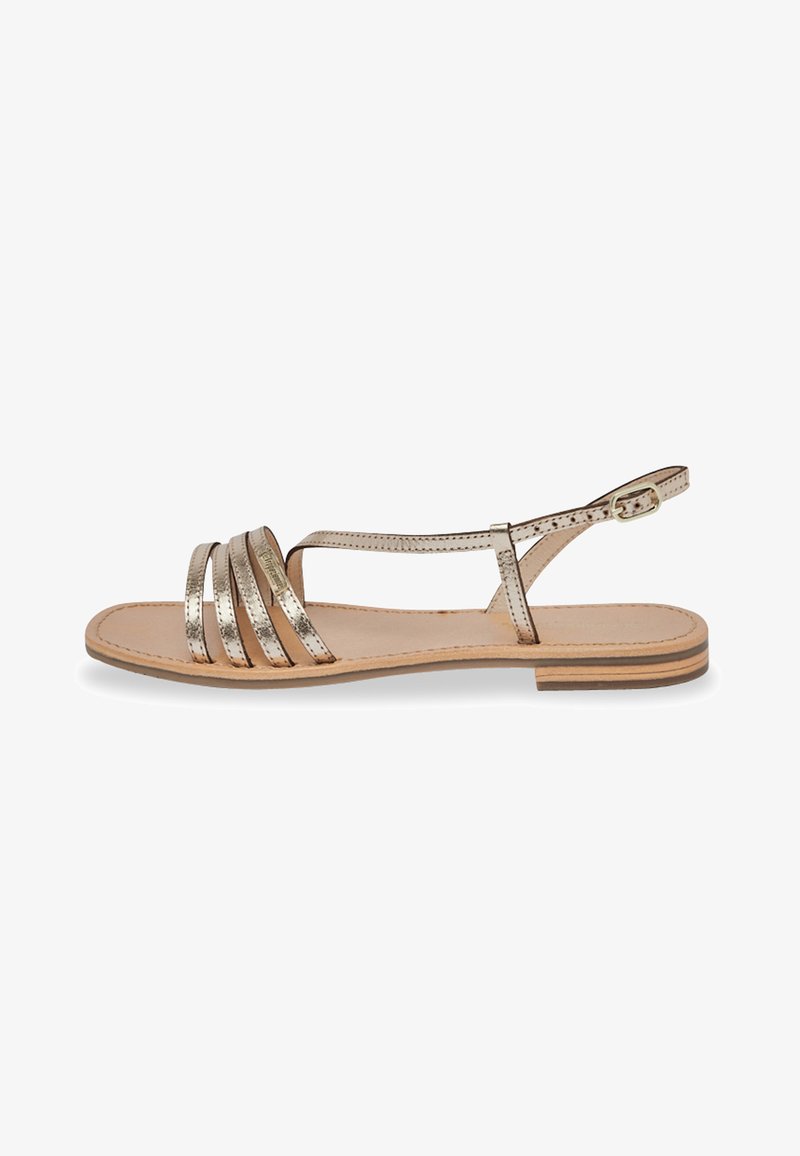 Sandali piatti con cinturini metallici dorati, design open toe, cinturino alla caviglia regolabile, soletta in pelle naturale e suola leggera in legno.