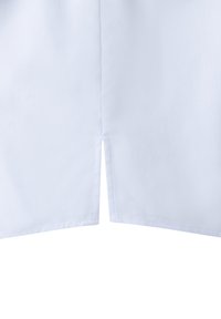 Unterer Abschnitt eines weißen Stoffs mit einer zentralen vertikalen Naht und einem kleinen Schlitz am unteren Saum.