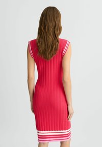 Tailliertes Rippkleid in leuchtendem Pink mit weißen und hellpinken horizontalen Streifen am Saum. Ärmelloses Design, strukturierter Strickstoff.