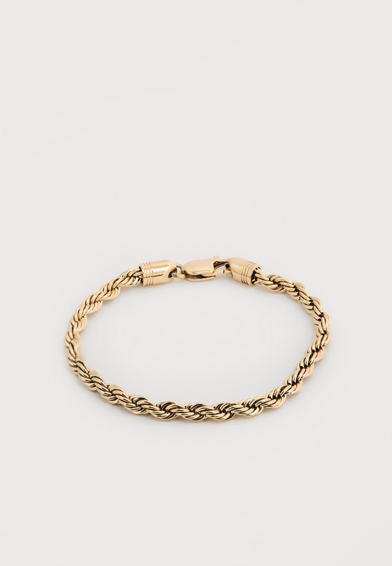Χρυσό βραχιόλι με πλεκτή αλυσίδα και κλείσιμο με καβούρι σε απλό φωτεινό φόντο.