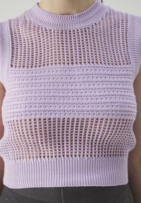 Lilac neulepaita, jossa on teksturoitu avoin kudontamalli, korkeakauluksellinen muotoilu ja tiukka ribbireuna, jossa on kerroksittain sijoitettuja vaaka- ja pystypakohkamalleja.