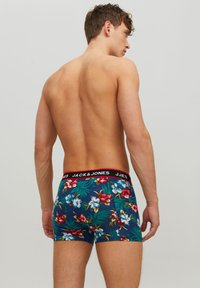 Férfi boxer alsónadrág fekete derékkal, amelyen a "JACK & JONES" felirat szerepel, kék trópusi virágmintával díszítve. Puha, rugalmas anyag.