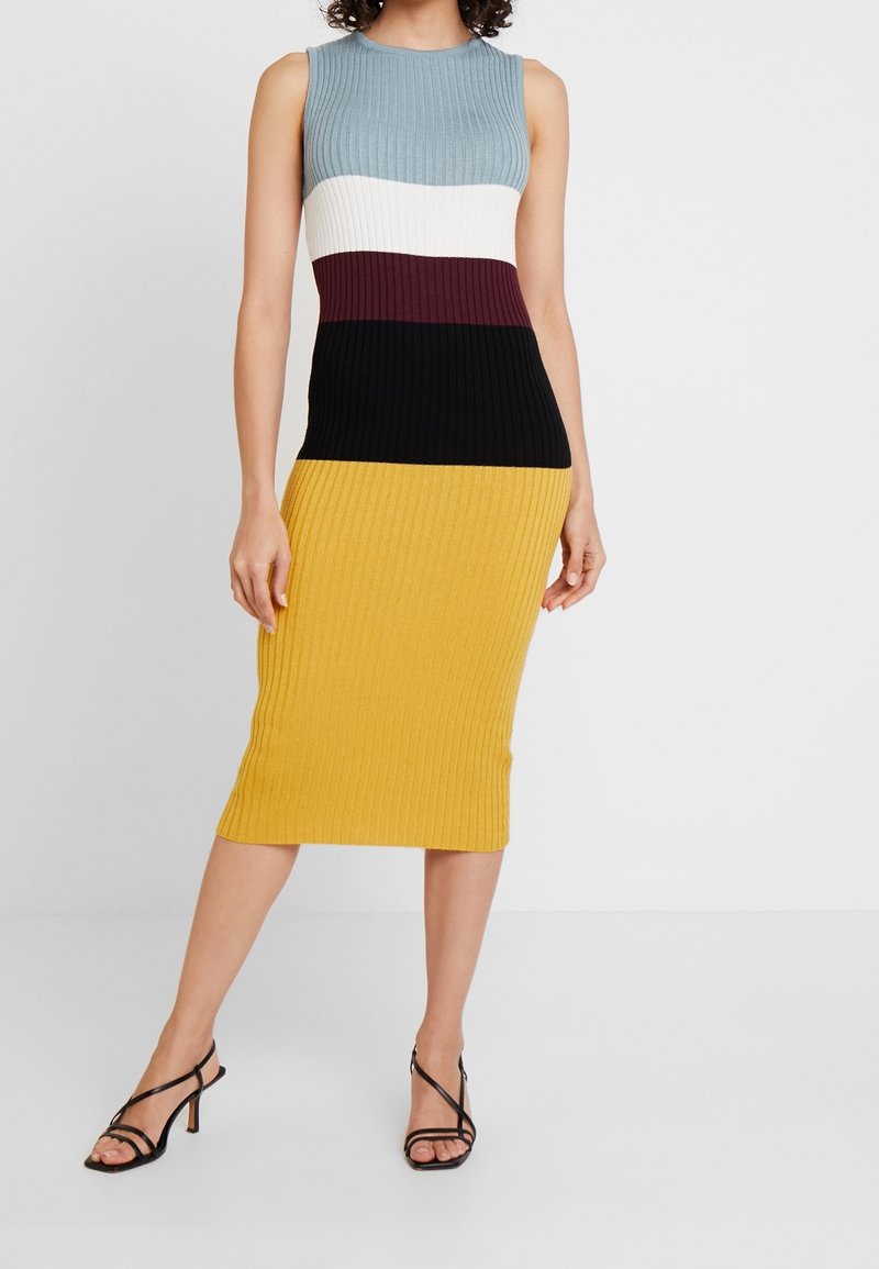 Ribbade stickade klänning med ärmlös design och färgblockerade sektioner i ljusblått, vitt, burgundy, svart och gult. Knälång.