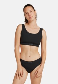 Top corto a coste nero e slip a vita alta coordinati, con un ampio elastico e design semplice, realizzati in morbido tessuto elastico.