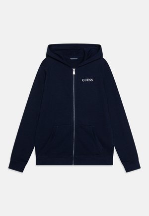 Granatowa bluza z kapturem na zamek błyskawiczny, z przednią kieszenią, długimi rękawami, kapturem i logo „GUESS” na lewej piersi.