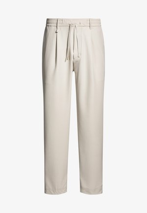 Beige, lässige Hose mit elastischem Bund und Kordelzug. Mit Falten an der Vorderseite und schmalem BeinDesign. Angenehme Textur.