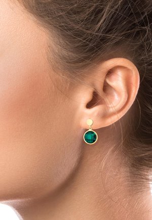 Gouden oorbellen met een ronde, facetten geslepen smaragdgroene glazen steen, hangend aan een kleine ronde stud.
