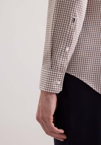 Camicia a maniche lunghe a quadri marrone e beige con polsini abbottonati e bottoni bianchi, caratterizzata da un orlo dritto e una texture liscia.