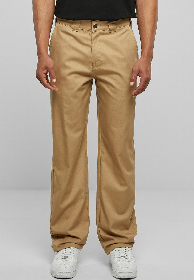 Khaki trousers with a straight-leg design, made from cotton blend fabric, featuring a button closure and belt loops, paired with white sneakers.