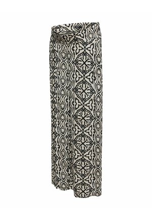 Pantalon à jambes larges et taille haute avec des motifs géométriques et floraux en noir et blanc sur un tissu beige clair.