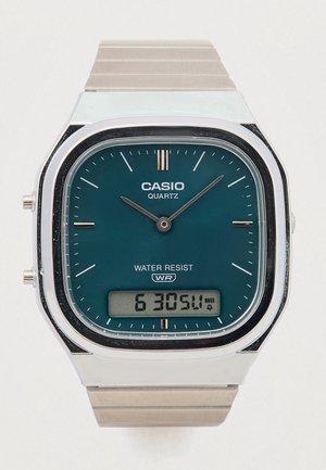 Casio kvarca pulkstenis ar taisnstūra formas zilganu ciparnīcu, nerūsējošā tērauda korpusu un sudraba metāla siksniņu. Iekļautas digitālās rādījumā un ūdensizturība.