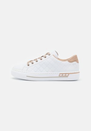 Baskets blanches matelassées avec des accents beiges, dotées de lacets ronds, d'une semelle en caoutchouc et de détails décoratifs sur les côtés en or et blanc.