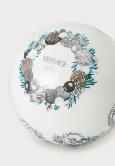 Ornement sphérique blanc décoré d’une disposition circulaire de boules argentées, dorées et bleues ainsi que de feuilles de pin vertes avec le texte "VERSACE."