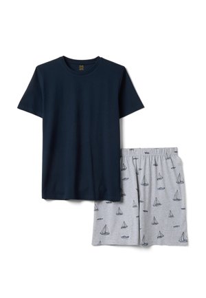 T-shirt bleu marine à manches courtes associé à un short gris clair avec de petits motifs de voiliers bleu marine.