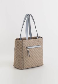 Beige gemusterte Tragetasche mit strukturiertem Design, ausgestattet mit hellblauen Trägern und einer äußeren Reißverschlusstasche. Texturierte Oberfläche, rechteckige Form.