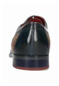 Scarpa in pelle blu scuro con lato in pelle intrecciata marrone, tacco piatto e interno rosso. Presenta linee pulite e una finitura liscia.