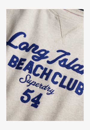 Beige sweater with blue embroidered text reading "Long Island Beach Club Superdry 54" on the front.