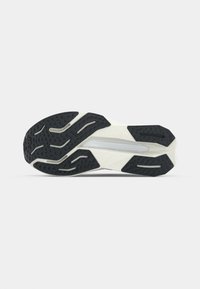 Shoe sole with a black rubber exterior and textured patterns, featuring a white and cream midsole with a streamlined design.