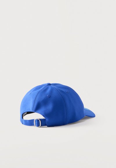 Casquette de baseball ajustable bleue vue de dos sur un fond clair uni, affichant une sangle à boucle métallique et des œillets de ventilation.