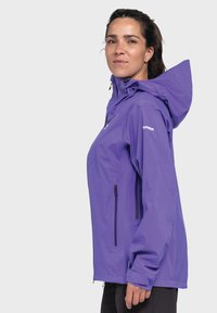 Purple waterproof jacket with a hood, front zip pocket, and elastic cuffs. Features a lightweight material and a sleek, fitted design.