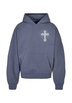 Huppari tummansinisena, jossa on etutasku ja vasemmassa rinnassa koristeellinen risti säteilevin viivojen kanssa.