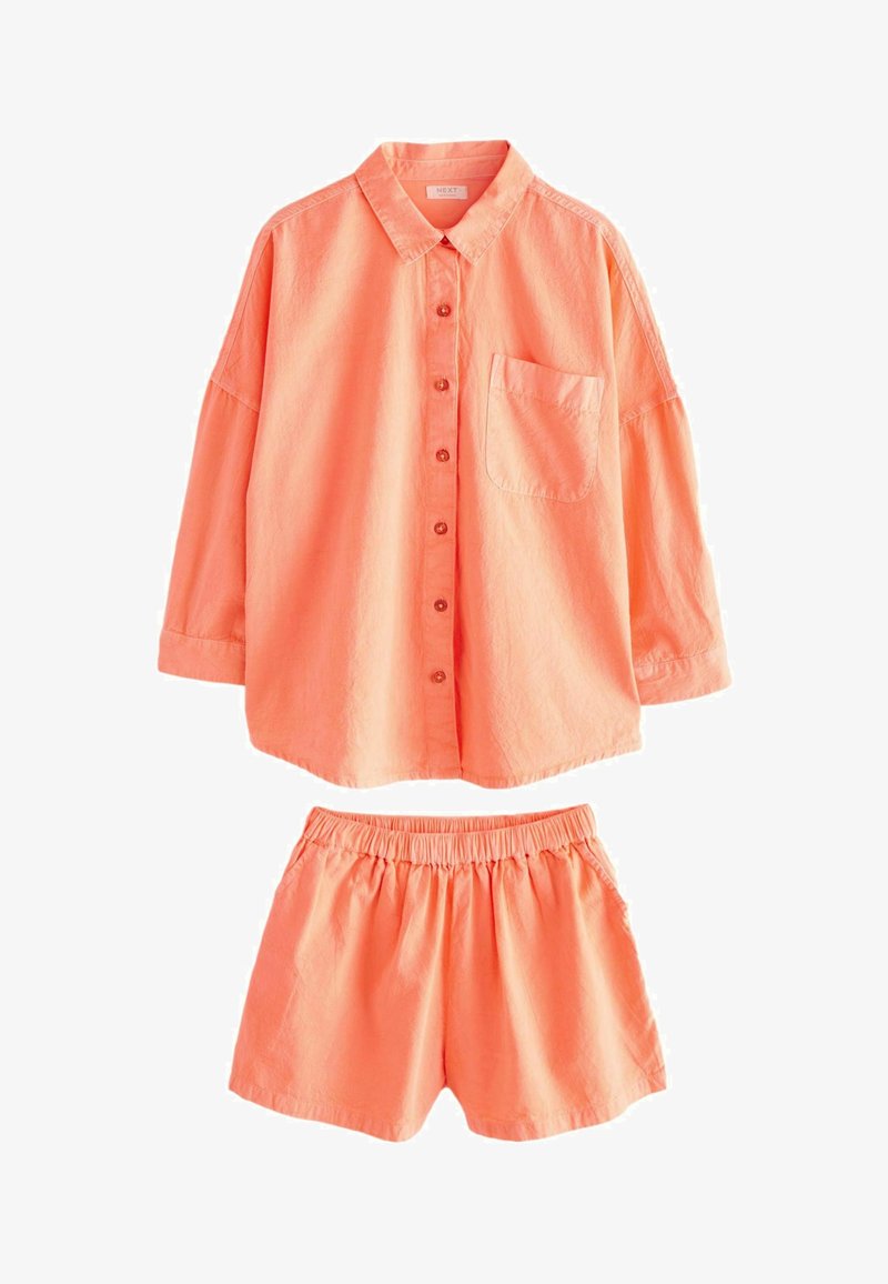 Peachfarvet, letvægts bomuldshem med lange ærmer og en brystlomme, parret med matchende elastiske shorts.