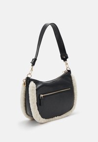 Borsa a tracolla in pelle nera con dettagli in pelliccia sintetica crema, forma curva, tracolla regolabile e tasca frontale con zip. Dettagli in metallo dorato.