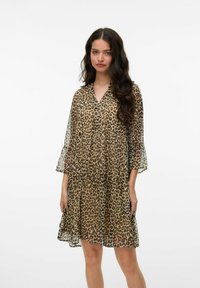 Abito in stampa leopardata realizzato in un tessuto leggero e trasparente, con un design fluido, scollo a v e maniche a tre quarti a campana, caratterizzato da strati sovrapposti.