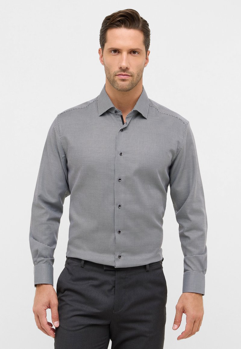 Camicia button-up con motivo a zigzag bianco e nero, dotata di colletto a punta e maniche lunghe con polsini abbottonati. Vestibilità sartoriale.