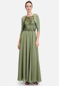 Maxi sukienka z miękkiej zielonej tkaniny z koronkowym topem, rękawami trzyczwartowymi i zwiewną spódnicą. Ozdobiona wyszywanymi wzorami kwiatowymi.