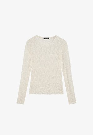 Hvid langærmet top med tekstureret stof med bølget design, rund hals og tætsiddende silhuet.