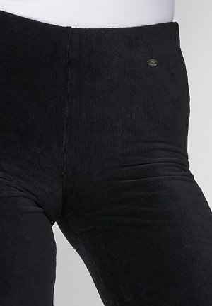 Mustritud mustad corduroy legginsid. Omavad kõrget vööd ja väikest kaubamärgi embleemi esiküljel.