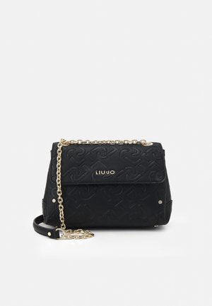 Schwarze, strukturierte Liu Jo Handtasche mit goldener Kettenriemen und Logo vorne, vor einem schlichten weißen Hintergrund.