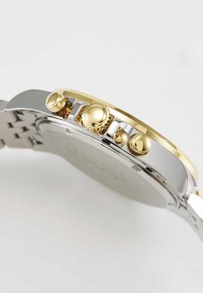 Stainless steel watch with a gold-tone bezel, three pushers, and a textured case. Features a silver bracelet and a smooth surface.