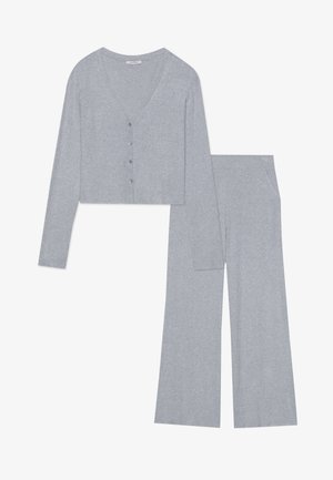 Jasnoszara, prążkowana zestaw dzianinowy, składający się z krótkiego kardiganu z zapięciem na guziki i długimi rękawami, w zestawie z szerokimi spodniami z kieszeniami.