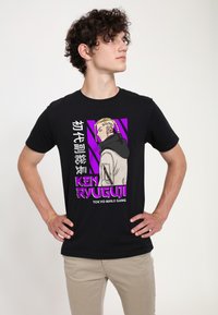 Černé bavlněné tričko s grafikou postavy v profilu s blond vlasy, umístěné na fialových pruzích a textových prvcích.